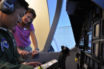 A student pilot enrolled in Undergraduate Remotely Piloted Aircraft Training at the 558th Flying Training Squadron, Joint Base San Antonio-Randolph, Texas, goes through the pre-flight checklist with an instructor July 10. The pilot was the first student to fly in a new, innovative T-6 Texan II simulator, which uses projects to create a 3-D training environment. The squadron is using 10 of the new simulators to train RPA pilots. EDITOR'S NOTE: The names were withheld for security concerns. (U.S. Air Force photo/Staff Sgt. Clinton Atkins)