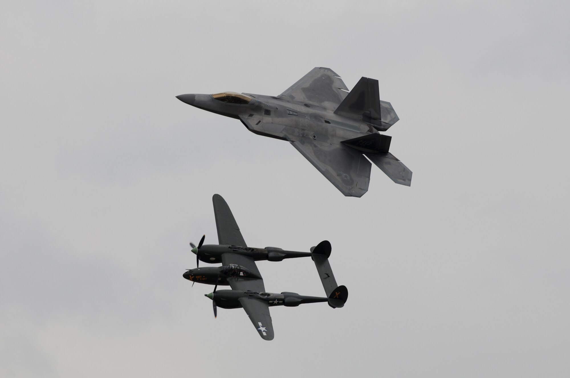 SIOUX FALLS, S.D. - The F-22 Raptor flies along side the P-38 Lightning in a heritage flight during the Sioux Falls Airshow 2012. Together, in the air, the demonstration reminds onlookers of the progress made since 1942. Each aircraft is the state-of-the-art in combat fighter design for its time.(National Guard photo by Tech. Sgt. Quinton Young)(Released)