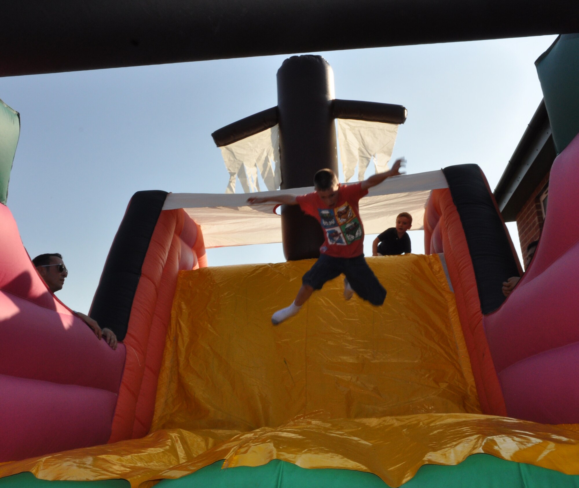 RAF MILDENHALL, England –Eli Bennett, 9, son of 100th Operations Support Squadron commander, Lt. Col. Christopher Bennett, slides down the bouncy slide during the Hearts Apart event, July 26, 2012 at Heritage Park, RAF Mildenhall. More than 15 families attended the event hosted by the 352nd Special Operations Group. (U.S. Air Force photo/Staff Sgt. Thomas Trower)