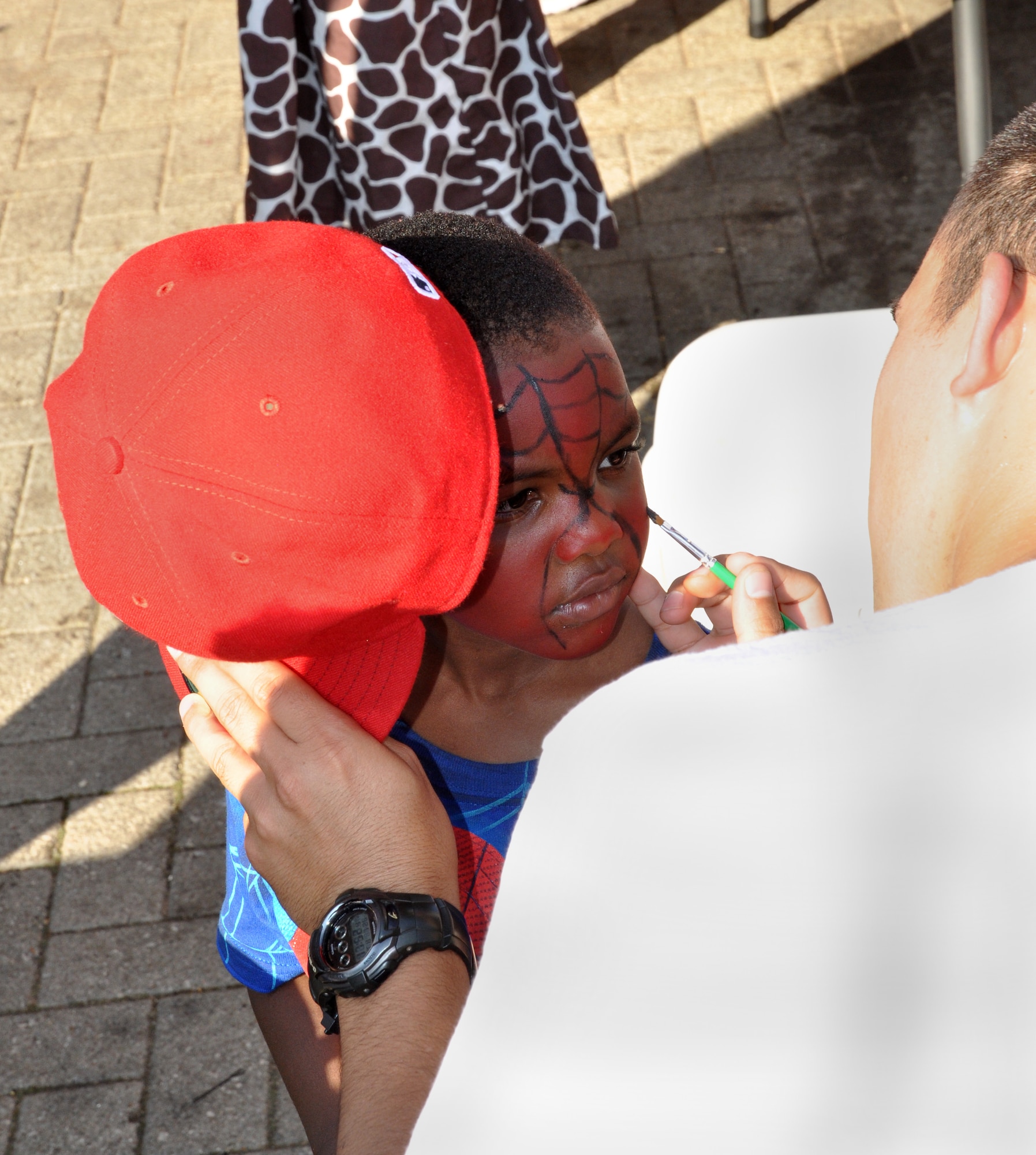 RAF MILDENHALL, England – Staff Sgt. Lawson Moss, 352nd Special Operations Group, paints Khanye Moss’, 4, face during the Hearts Apart event, July 26, 2012 at Heritage Park, RAF Mildenhall. This monthly event is held for families of deployed Airmen to show the families appreciation for their support of their loved one. This month’s dinner was sponsored by the 352nd SOG. (U.S. Air Force photo/Staff Sgt. Thomas Trower)