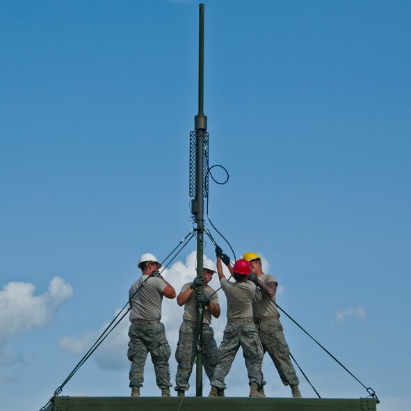 728th Air Control Squadron digital maintenance technicians erect a radio frequency antenna on a mobile joint tactical information distribution system module during a deployment readiness exercise called Bison Fury July 24 at Eglin Air Force Base, Fla.  This exercise marks the last large-scale exercise for the squadron, which is scheduled to be deactivated in 2013.  (U.S. Air Force photo/Samuel King Jr.)