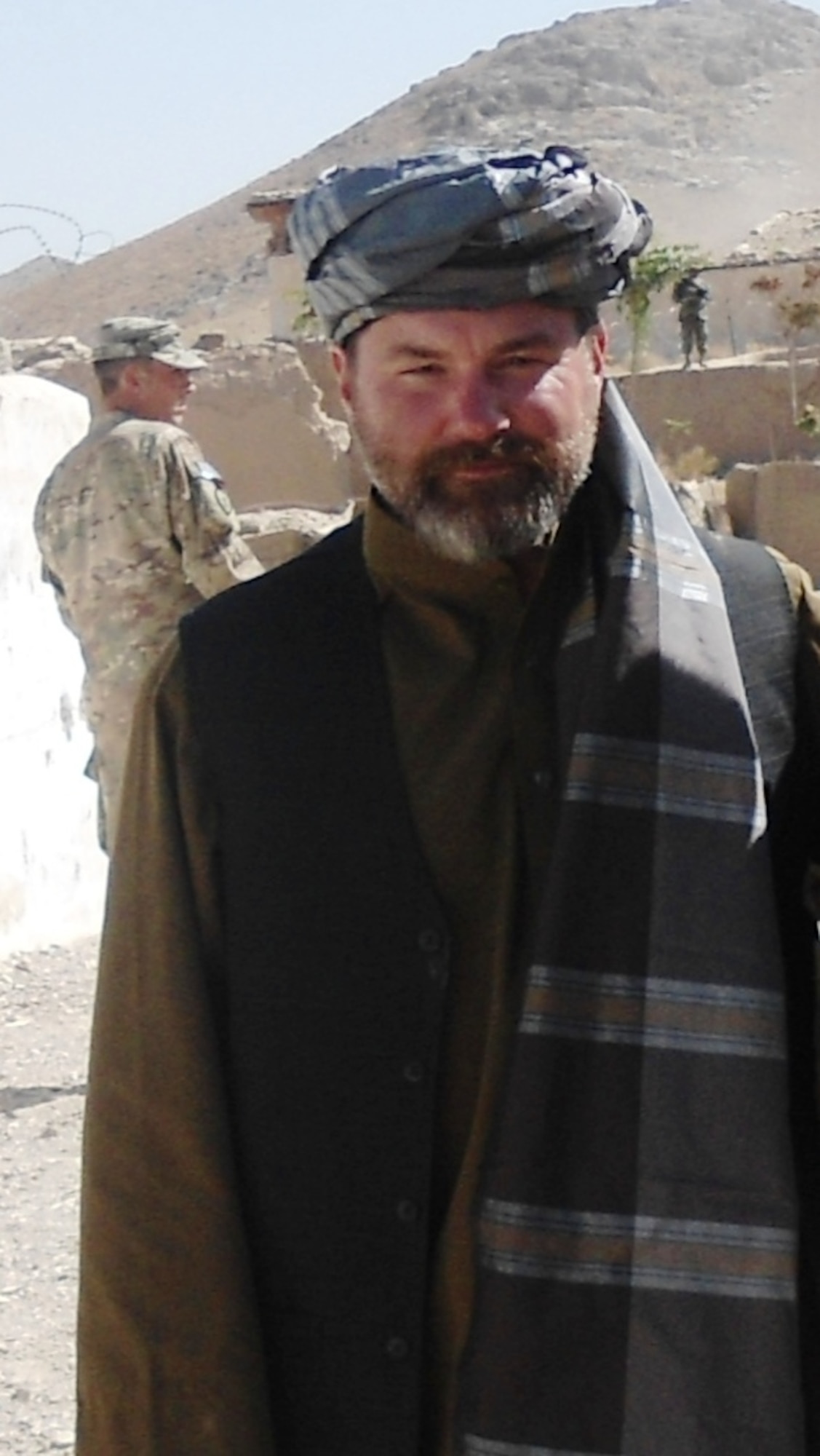 Maj. John Matthews smiles for a portrait in traditional Afghan clothing, during one of his deployments to Afghanistan. Earning the trust of the local population was one of the first hurdles that Matthews had to overcome as he worked with the local peace and reintegration team. By wearing national dress, he helped locals see past glaring cultural differences and come up with creative and effective solutions. (Courtesy photo/Maj. John Matthews) 
