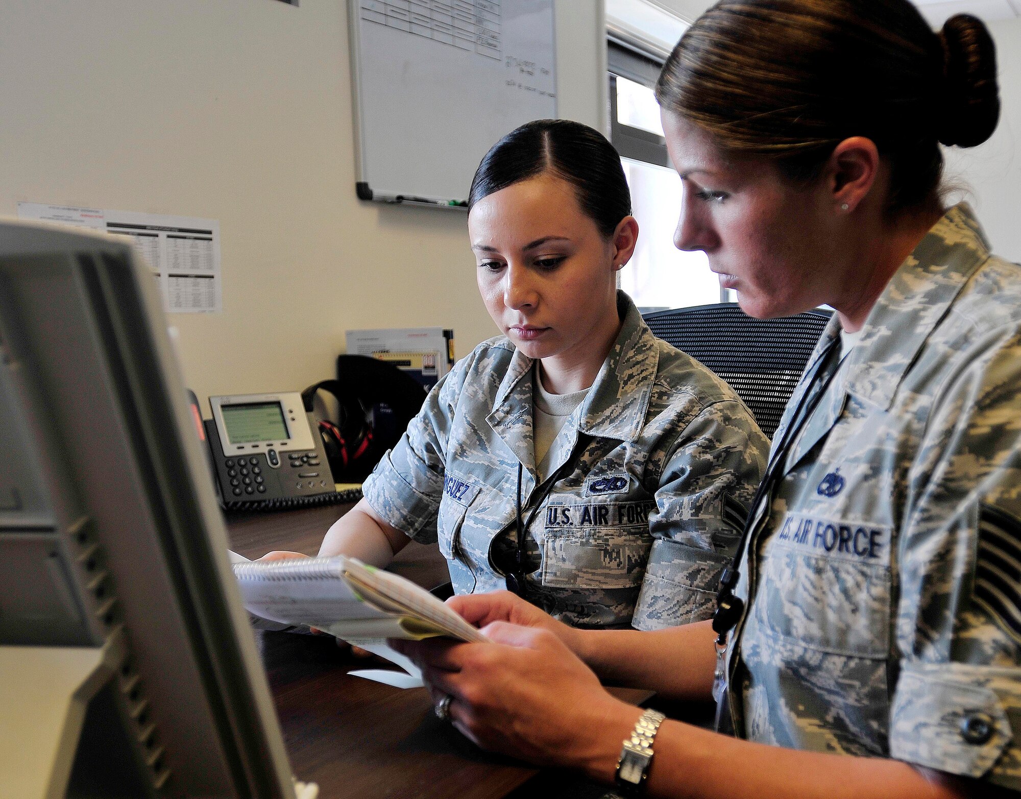 ROYAL AIR FORCE LAKENHEATH, England - Airman 1st Class Erika Rodriguez (left), 48th Maintenance Operations Squadron dedicated Helicopter Maintenance Unit analyst, receives guidance from Tech. Sgt. Anna Davis, 48th MOS analysis section chief, in building 1313, July 25, 2012.  Rodriguez was nominated for a Liberty Spotlight because she displays the core value of "Excellence in All We Do." (U.S. Air Force photo by Senior Airman Tiffany M. Deuel)