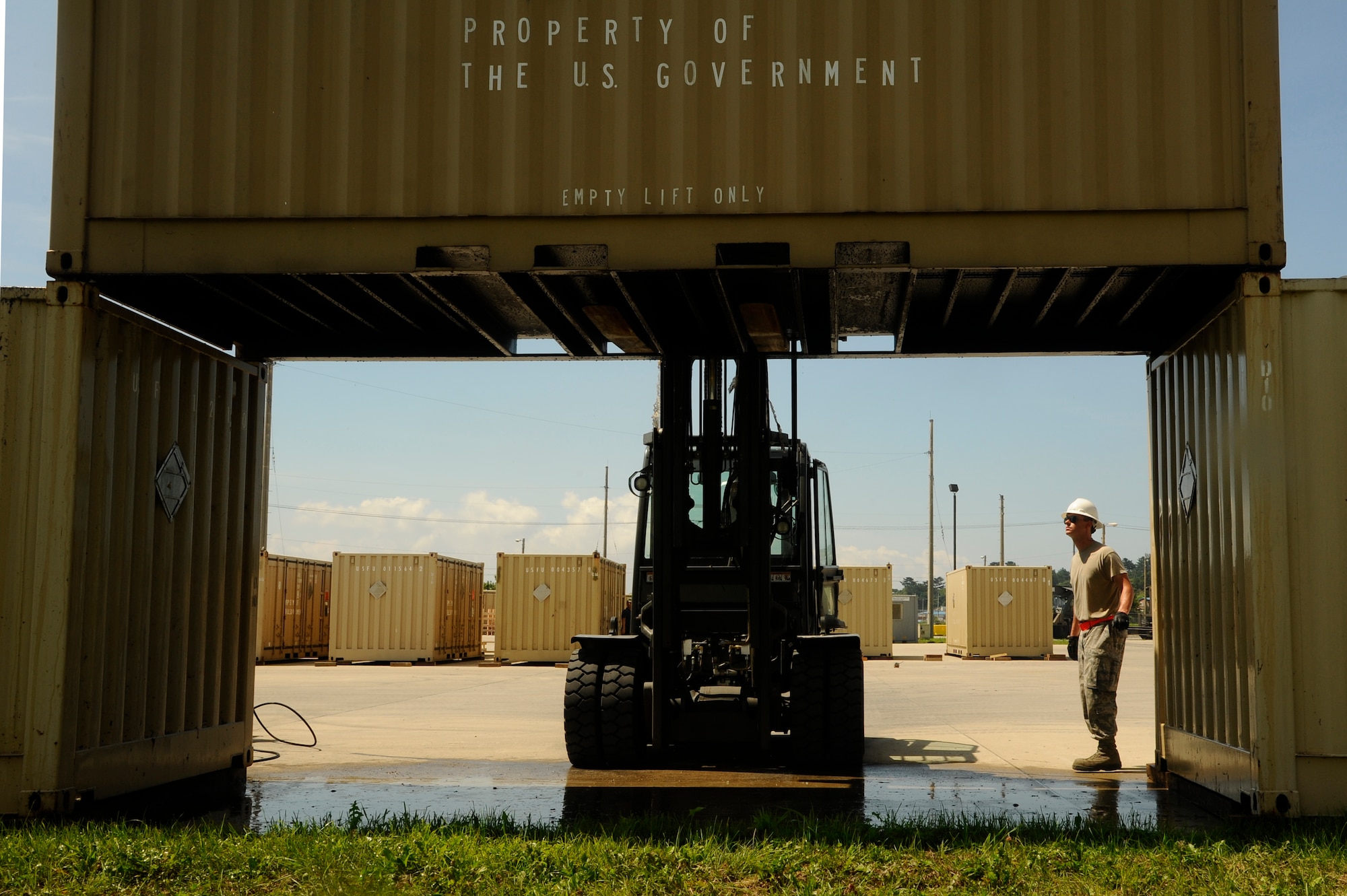 Senior Airman Evan Pressman, right, 8th Maintenance Squadron Munitions Storage specialist, guides Senior Airman Reginald Hinson, 8th MXS Munitions Storage specialist, into position to place a munitions storage container for cleaning at Kunsan Air Base, Republic of Korea, July 25, 2012. There are 150 containers that must be cleaned and inspected for shipment of old and new munitions. (U.S. Air Force photo/Senior Airman Marcus Morris)