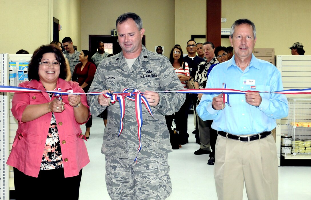 Lt. Col. Robert Burns, 36th Mission Support Group deputy commander (center), Brandy Untalan, General Services Administration customer services director (left) and David Dubinsky, National Institute for the Significantly Handicapped executive director cut the ribbon to mark the grand opening at the ServMart here July 26. The ServMart will save tax-payer dollars by providing supplies at competitive pricing. (U.S. Air Force photo/Airman 1st Class Mariah Haddenham/Released)
