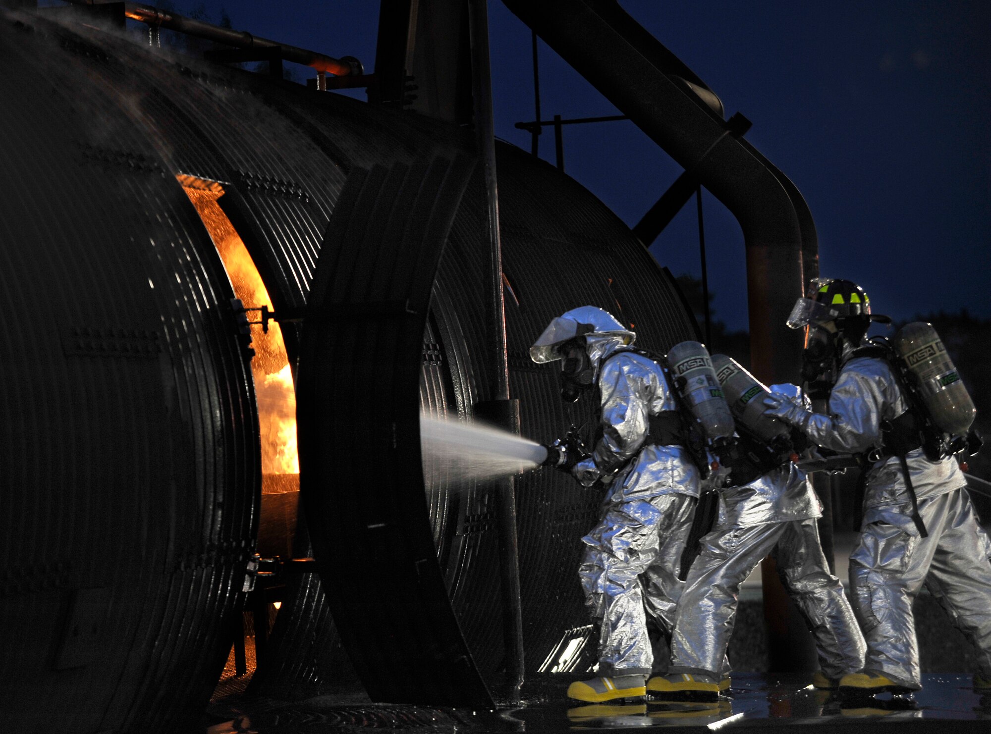 U.S. Air Force firefighters with the 35th Civil Engineer Squadron direct an incident commander on what to do as he extinguishes a fire during a live fire demonstration at Misawa Air Base, Japan, July 26, 2012. The aircraft fire trainer gives firefighters a controlled environment to train and perfect the skills needed in case of a real emergency. (U.S. Air Force photo by Staff Sgt. Nathan Lipscomb/Released)