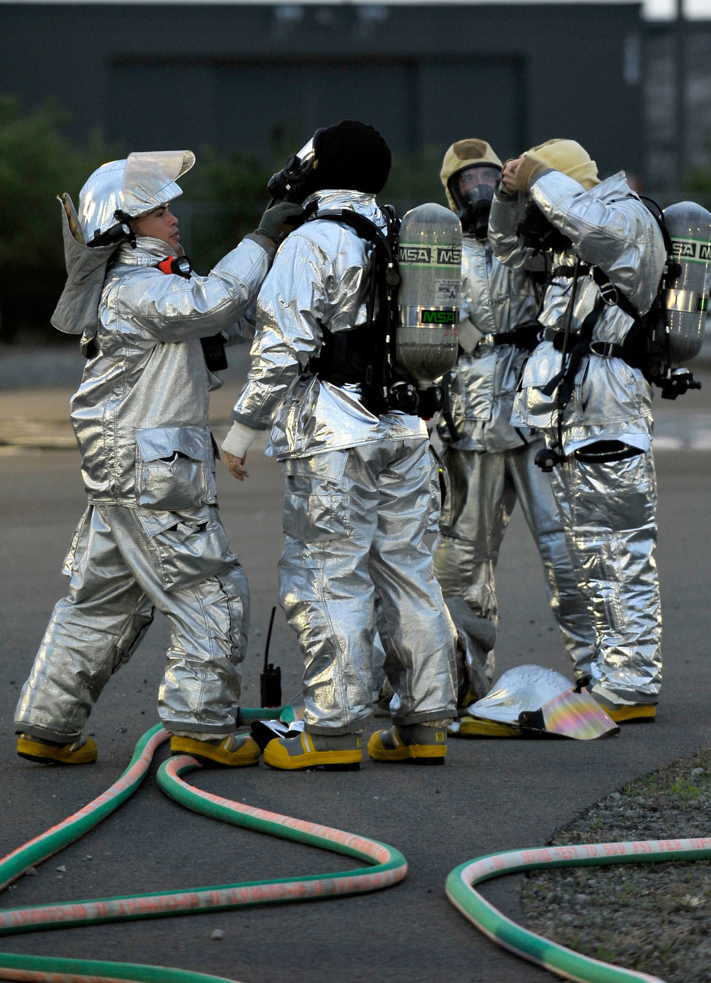 U.S. Air Force firefighters with the 35th Civil Engineer Squadron help incident commanders don fire protection gear before a live fire demonstration at Misawa Air Base, Japan, July 26, 2012. The demonstration gave incident commanders first-hand knowledge of what firemen do when responding to an emergency. (U.S. Air Force photo by Staff Sgt. Nathan Lipscomb/Released)