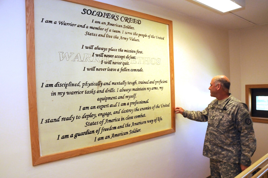 Col. Craig Cutter, Deputy Commander, 19th Expeditionary Sustainment Command, looks over the Soldiers Creed in the stairwell of Daegu High School.  The creed was originally painted on the wall by soldiers when the building was used as a barracks.  The U.S. Army Corps of Engineers, Far East District renovated the barracks to be used as a school.  The mural was intentionally left uncovered to reflect the history of the building and as a symbol of the school’s mascot: the Warriors.  (Photo by Patrick Bray)