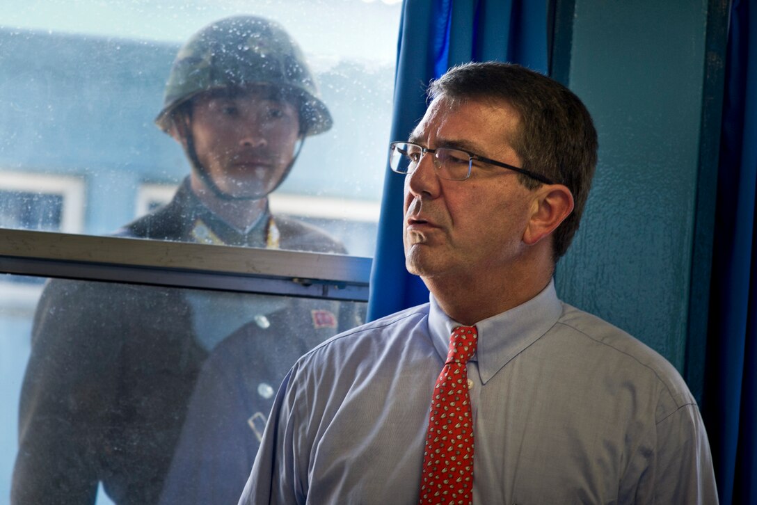 A North Korean soldier watches as U.S. Deputy Defense Secretary Ashton B. Carter tours the Military Armistice Commission building in Panmunjom in the demilitarized zone separating North and South Korea, July 26, 2012.