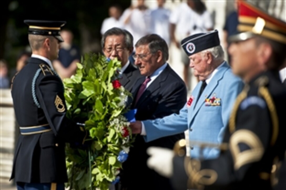 A member of the honor guard brings a wreath to Defense Secretary Leon E. Panetta as South Korean Ambassador Choi-Young jin looks on during a ceremony to mark the 59th anniversary of the signing of the Korean War armistice at Arlington National Cemetery in Arlington, Va., July 27, 2012.
