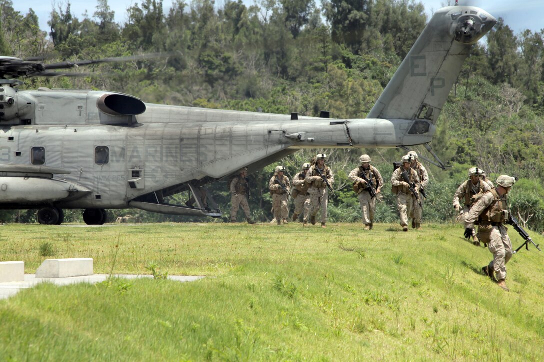 KIN BLUE, Okinawa, Japan – Marines from the Tactical Recovery of Aircraft and Personnel team of the 31st Marine Expeditionary Unit, rush from the back of a CH-53E Super Stallion helicopter from Marine Medium Helicopter Squadron 262 (Reinforced), during a training mission to rescue a downed pilot here, July 26. The 31st MEU is the Marine Corps' force in readiness for the Asia-Pacific region.