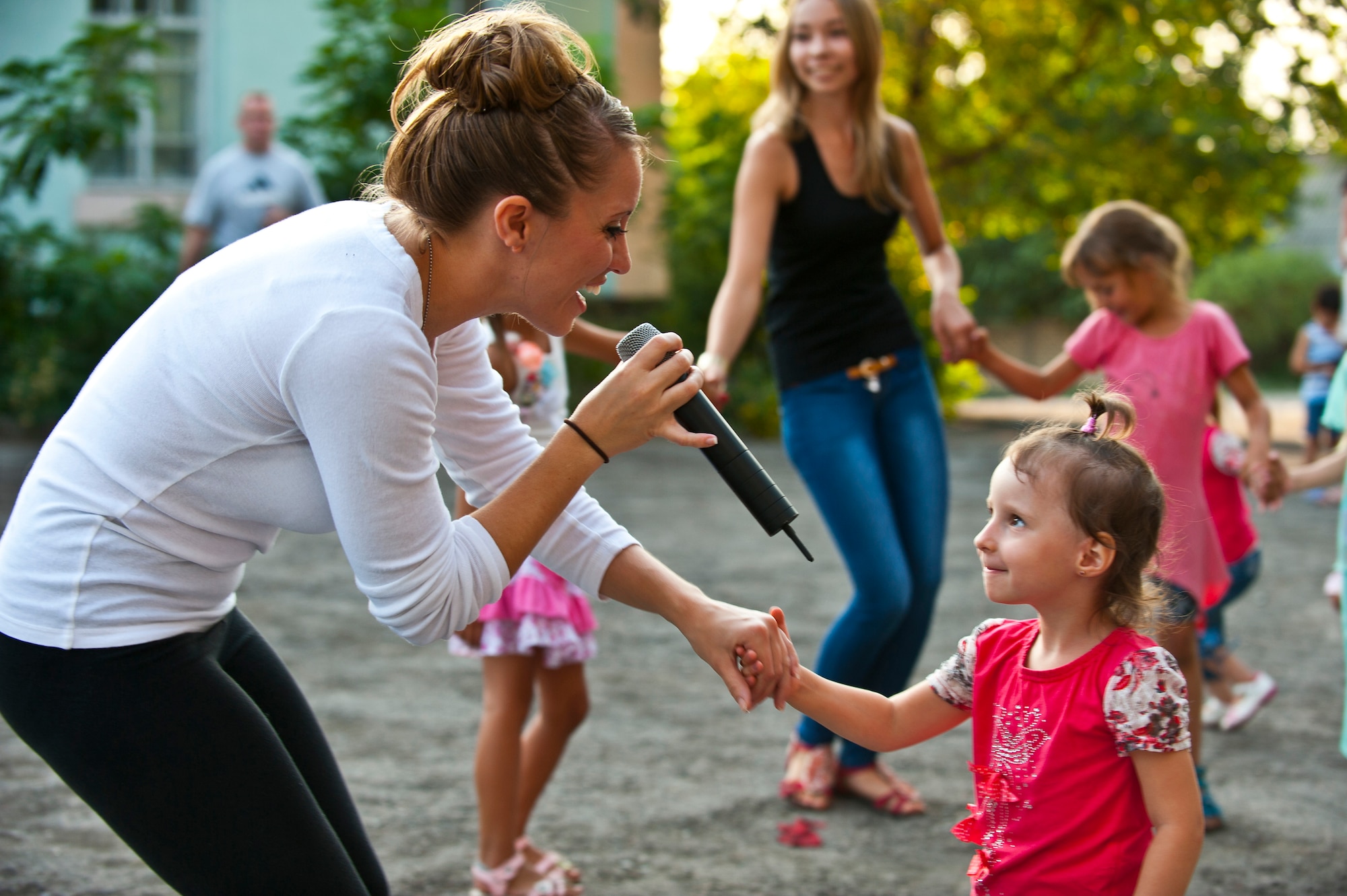 Staff Sgt. Samantha Renner sings to Shreeva, 4, during a U.S. Air Forces Central Band "Vector" performance at the Maevka House of Culture in Maevka Village, Kyrgyzstan, July 27, 2012. Renner volunteered to sing with the band for their final concert in their nine-day tour in Kyrgyzstan. Renner is a 376th Expeditionary Logistics Readiness Squadron resource controller at the Transit Center at Manas, Kyrgyzstan and is deployed out of Luke Air Force Base, Ariz. She is a native of Fremont, Neb.(U.S. Air Force photo/Senior Airman Brett Clashman)