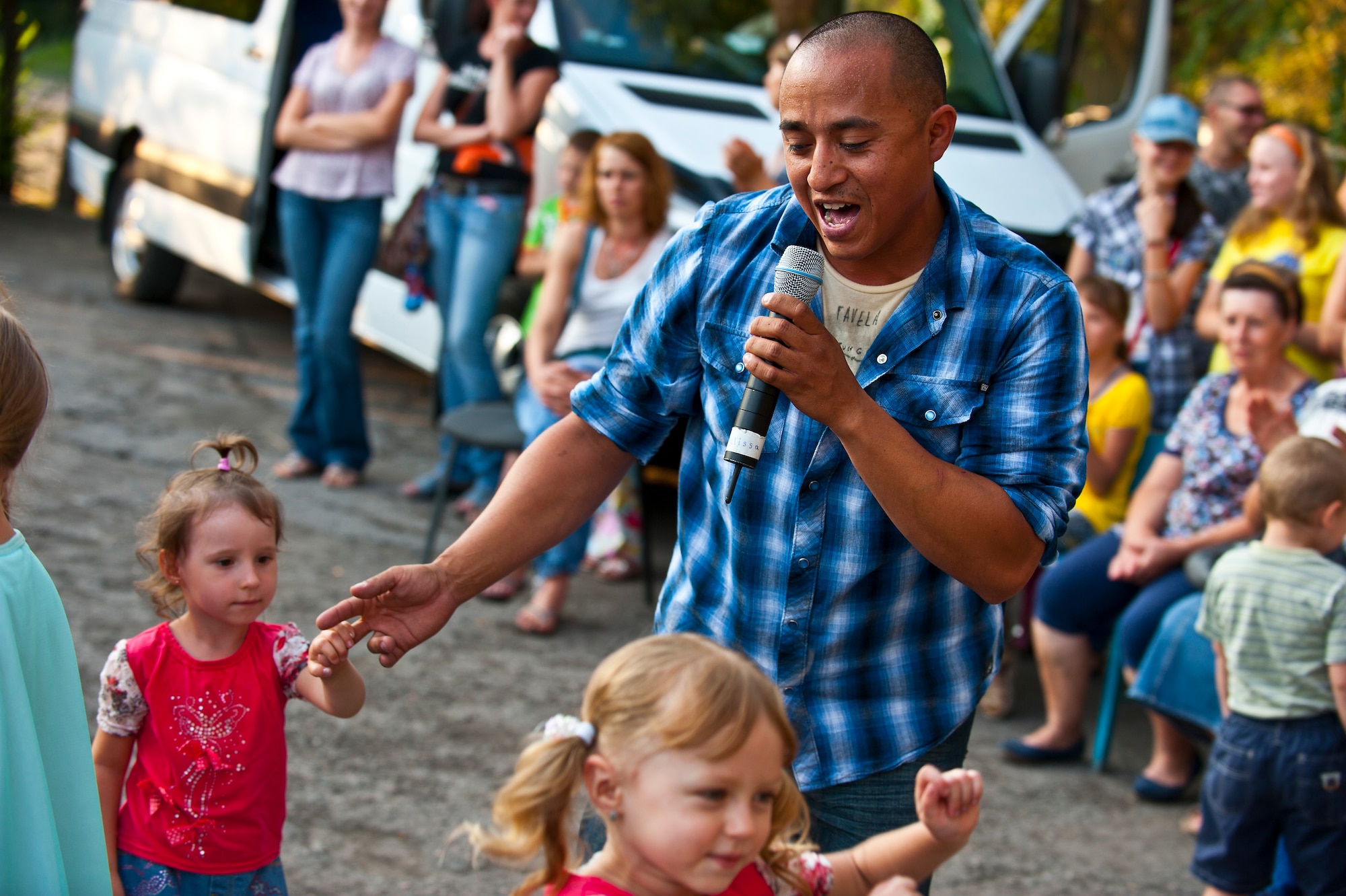 Senior Airman David Rodriguez dances with Kyrgyz Republic children during a U.S. Air Forces Central Band "Vector" performance at the Maevka House of Culture in Maevka Village, Kyrgyzstan, July 27, 2012. More than 200 people from the village gathered to watch the band perform their final concert, closing out a nine-day tour in Kyrgyzstan. Rodriguez is deployed out of the Channel Islands Air National Guard Station, Calif. He is a native of Southgate, Calif. (U.S. Air Force photo/Senior Airman Brett Clashman)