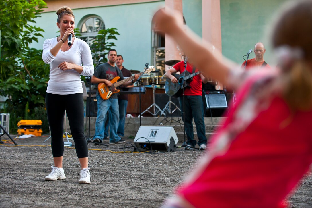 Staff Sgt. Samantha Renner sings during a U.S. Air Forces Central Band "Vector" performance at the Maevka House of Culture in Maevka Village, Kyrgyzstan, July 27, 2012. Renner volunteered to sing with the band for their final concert of their nine-day tour in Kyrgyzstan. Renner is a 376th Expeditionary Logistics Readiness Squadron resource controller at the Transit Center at Manas, Kyrgyzstan and is deployed out of Luke Air Force Base, Ariz. She is a native of Fremont, Neb.(U.S. Air Force photo/Senior Airman Brett Clashman)