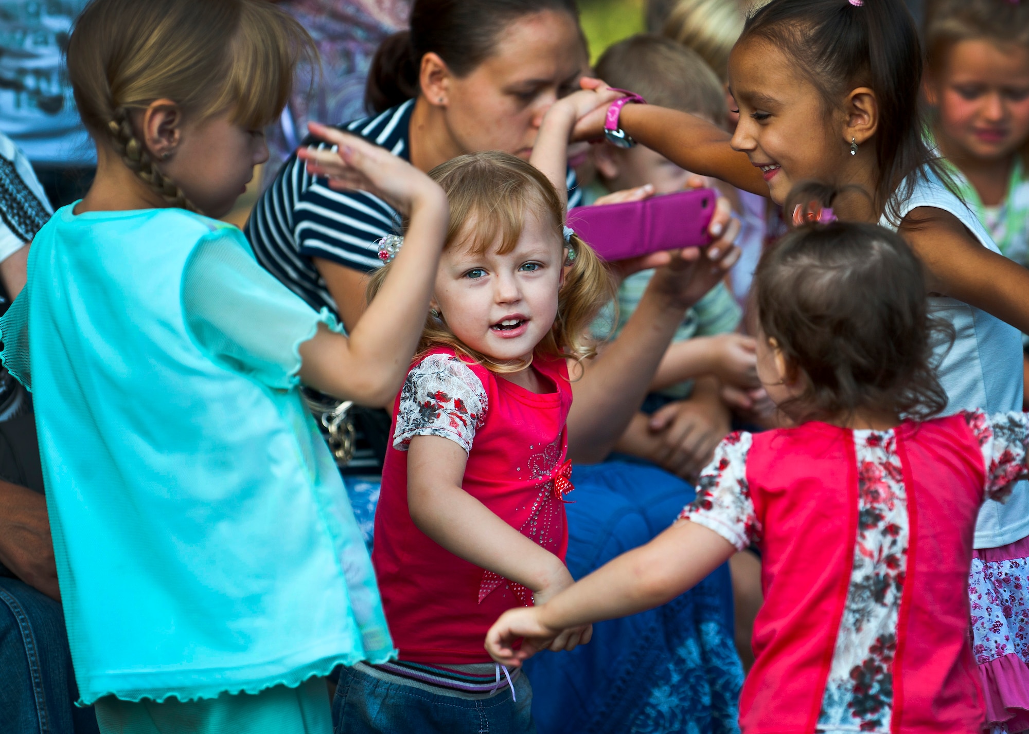 Akara, five, dances with other Kyrgyz Republic children during a U.S. Air Forces Central Band "Vector" performance at the Maevka House of Culture in Maevka Village, Kyrgyzstan, July 27, 2012. More than 200 people from the village gathered to watch the band perform their final concert, closing out a nine-day tour in Kyrgyzstan. (U.S. Air Force photo/Senior Airman Brett Clashman)