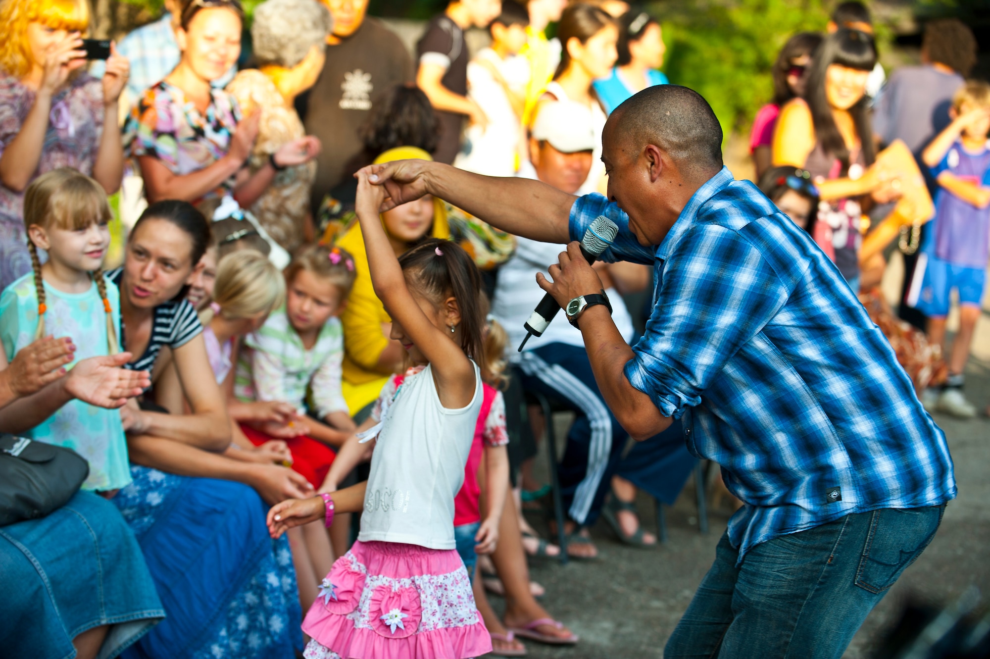 Senior Airman David Rodriguez dances with Almineka, 11, during a U.S. Air Forces Central Band "Vector" performance at the Maevka House of Culture in Maevka Village, Kyrgyzstan, July 27, 2012. More than 200 people from the village gathered to watch the band perform their final concert, closing out a nine-day tour in Kyrgyzstan. Rodriguez is deployed out of the Channel Islands Air National Guard Station, Calif. He is a native of Southgate, Calif. (U.S. Air Force photo/Senior Airman Brett Clashman)