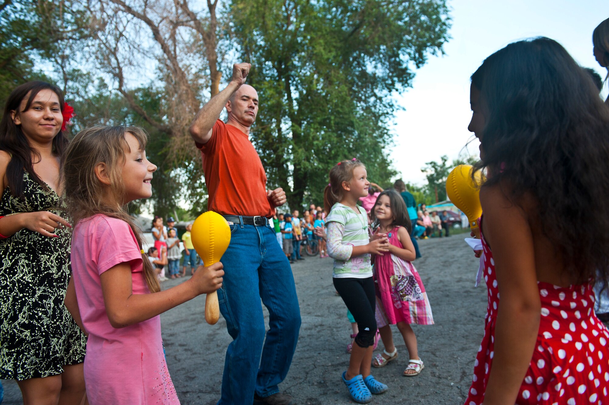 Tech. Sgt. Daniel Plaster dances with Kyrgyz Republic locals during a U.S. Air Forces Central Band "Vector" performance at the Maevka House of Culture in Maevka Village, Kyrgyzstan, July 27, 2012. Vector played their final concert of their nine-day tour in Kyrgyzstan. Plaster is deployed out of the Channel Islands Air National Guard Station, Calif. He is a native of Redundo Beach, Calif. (U.S. Air Force photo/Senior Airman Brett Clashman)