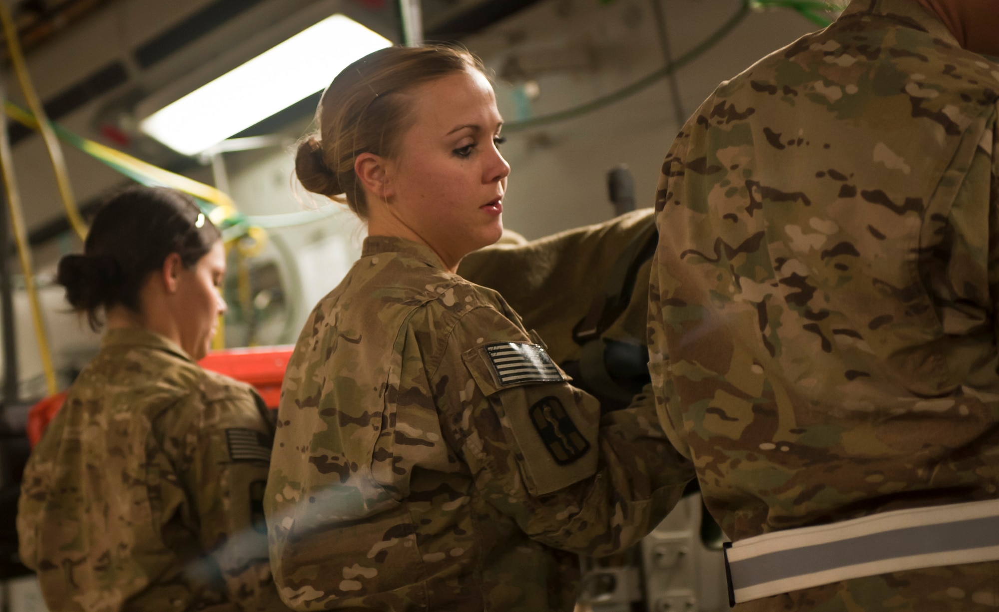 A1C Ariel Penny, 455th Expeditionary Medical Operation Squadron medical technician at the Craig Joint Theater Hospital, helps a patient aboard a C-17 Globemaster III at Bagram Airfield, Afghanistan, July 23, 2012. The CASF is the relay between the Craig Joint Theater Hospital and aeromedical evacuation missions. (U.S. Air Force Photo/Capt. Raymond Geoffroy)