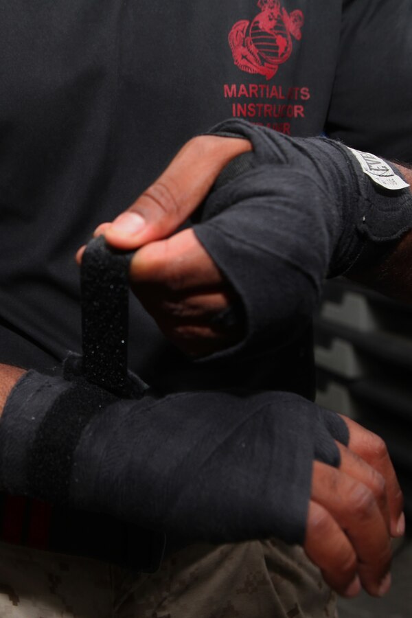 CAMP BUEHRING, Kuwait (July 25, 2012) - Sgt. Jose Alvarez, a Bronx, N.Y., native and 2nd degree martial arts instructor trainerwith Battalion Landing Team 1st Battalion, 2nd Marine Regiment, 24th Marine Expeditionary Unit, wraps his hands in preparation for a demonstration as part of aMarine Corps Martial Arts Program, or MCMAP, instructor trainer course in Camp Buehring, Kuwait, July 25, 2012. The 24th MEU is deployed with the Iwo Jima Amphibious Ready Group as a U.S. Central Command theater reserve force providing support for maritime security operations and theater security cooperation efforts in the U.S. 5th Fleet area of responsibility. (Official Marine Corps photo by Sgt. Richard Blumenstein)