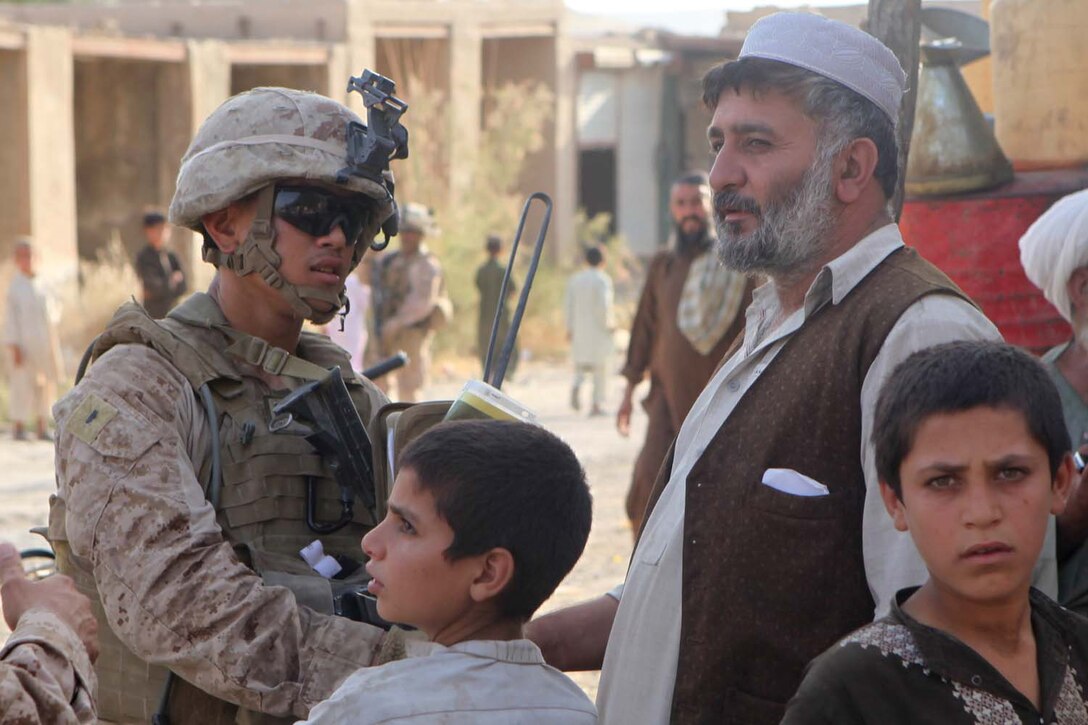 First Lt. Bryant Yee, an adviser with Police Advisor Team 4, talks to a shopkeeper in Kajaki district, Afghanistan, July 10, 2012. The PAT is responsible for training and supporting the Afghan Uniformed Police to help them become self-sufficient.