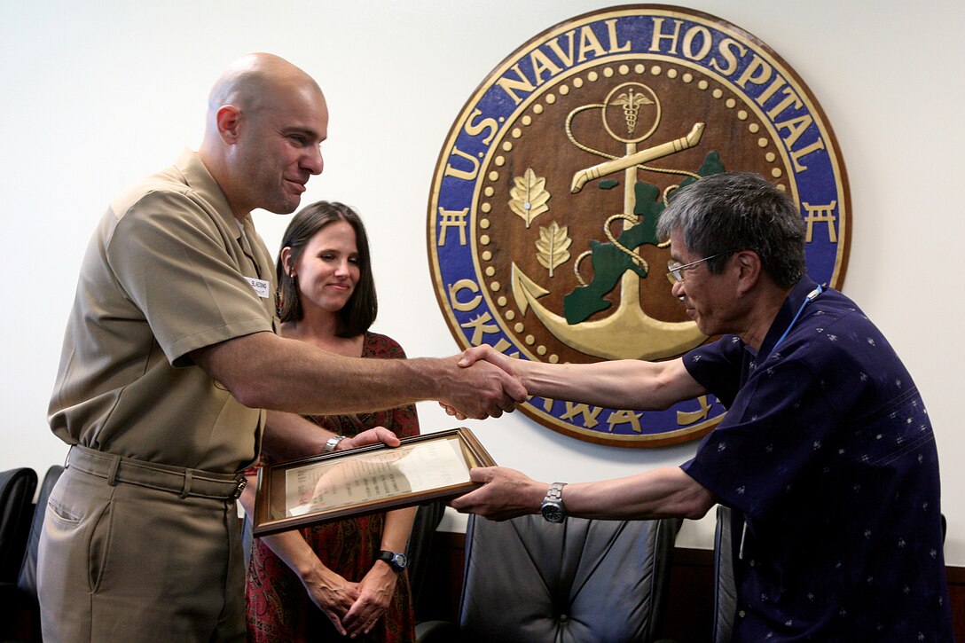 Navy Lt. Carl R. Blaesing receives a certificate of appreciation from Kenji Tanaka at United States Naval Hospital Okinawa May 23. The certificate recognizes Blaesing for his outstanding support of the Japanese plant quarantine service since 2009. The quarantine service is responsible for inspecting all equipment coming into any Okinawa port, according to Blaesing. There are seven ports on Okinawa and all incoming military controlled equipment must be checked. Blaesing is the environmental health officer and head of the USNH preventative medicine department. Tanaka is the director of the Naha Plant Quarantine and Protection Station, Ministry of Agriculture, Forestry and Fisheries, government of Japan. 
