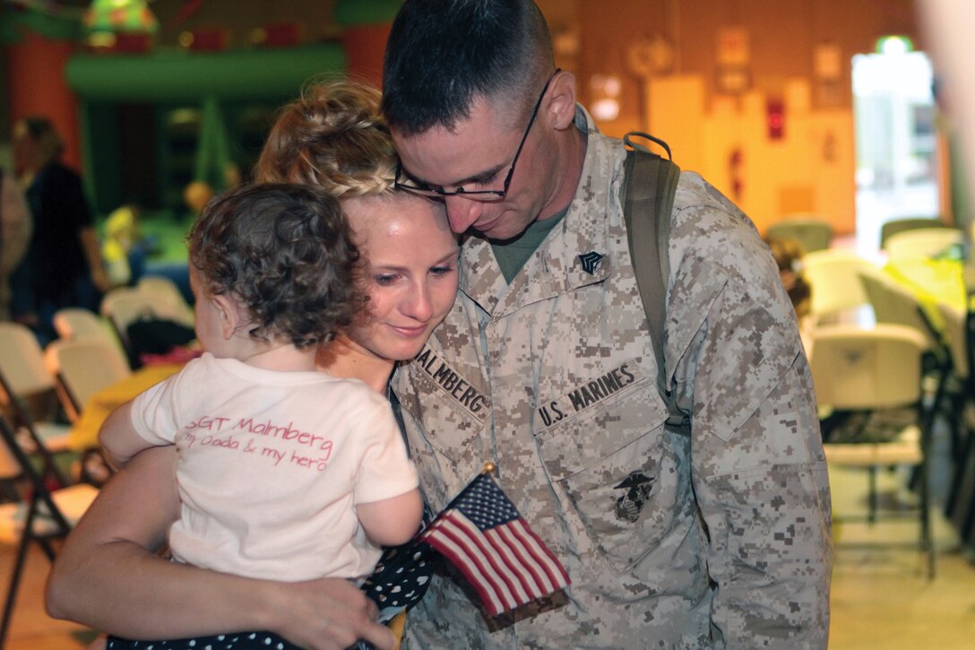 Sgt. Daniel G. Malmberg hugs his wife Raechel and their daughter Evelyn upon his return to Camp Hansen from a seven-month deployment to Afghanistan. Malmberg, a military policeman with 9th Engineer Support Battalion, 3rd Marine Logistics Group, III Marine Expeditionary Force, deployed with 9th ESB, 1st MLG (Forward), I MEF (FWD). 
