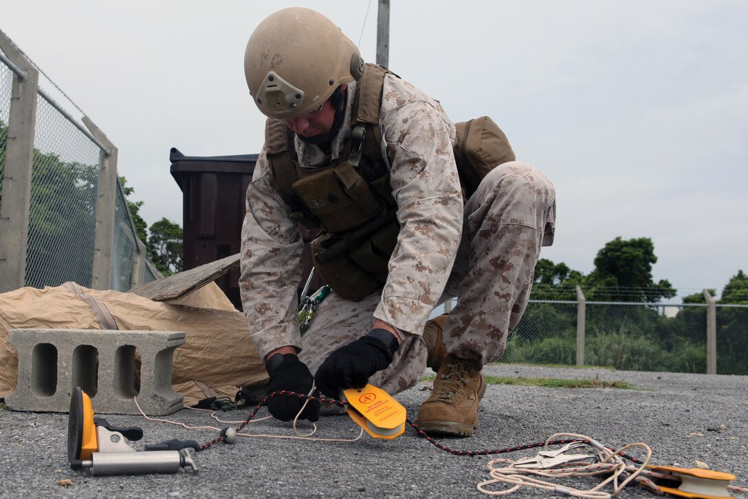 Staff Sgt. Bradley M. Passage prepares a tool used to open the window of a vehicle harboring a simulated vehicle-borne IED during training at Kadena Air Base June 11. Passage is an explosive ordnance disposal technician with Marine Wing Support Squadron 172, Marine Aircraft Group 36, 1st Marine Aircraft Wing, III Marine Expeditionary Force. 
