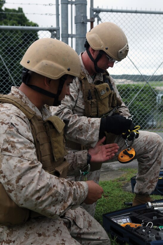 Sgt. Paul I. Mead and Staff Sgt. Bradley M. Passage prepare equipment to approach a simulated vehicle-borne IED during training at Kadena Air Base June 11. The Marines train regularly, so they are prepared for any obstacles they may face in a combat environment. Mead and Passage are explosive ordnance disposal technicians with MWSS-172. 
