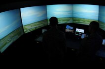 ANDERSEN AIR FORCE BASE, Guam - Two air traffic controllers from the 36th Operations Support Squadron train on the air traffic control tower simulator July 20. The simulator allows controllers to perfect their skills of controlling aircraft before performing the actual task. (U.S. Air Force photo by Senior Airman Carlin Leslie/Released)