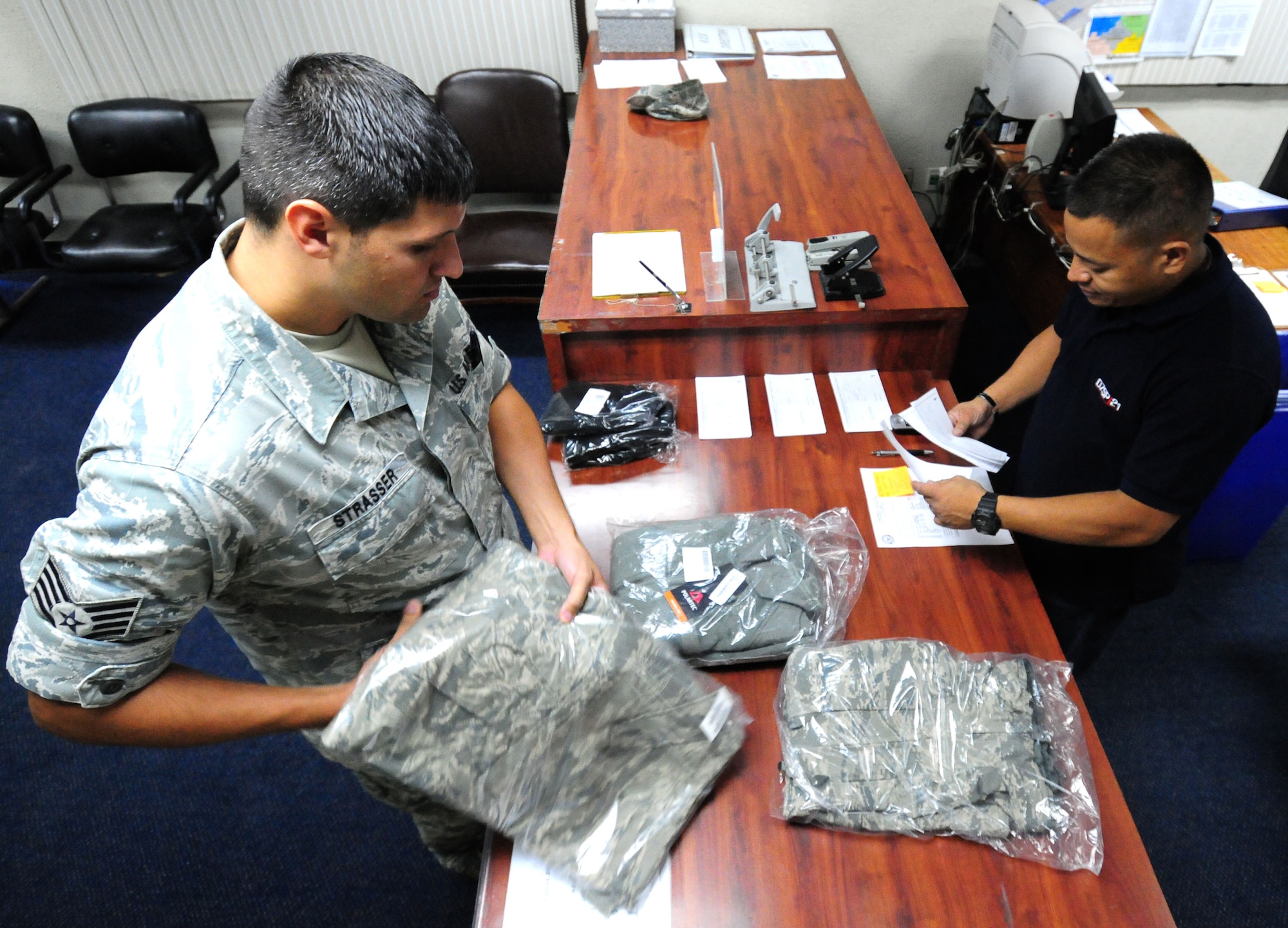 ANDERSEN AIR FORCE BASE, Guam— Staff Sgt. Kurtis Strasser, 734th Air Mobility Squadron unit deployment manager, receives an order from Duane Chargualaf, 36th Logistics Readiness Squadron individual equipment unit warehouse specialist, July 20. Approximately 80 to 100 individual issue requests are filled by IEU daily. (U.S Air Force photo by Senior Airman Benjamin Wiseman/Released)