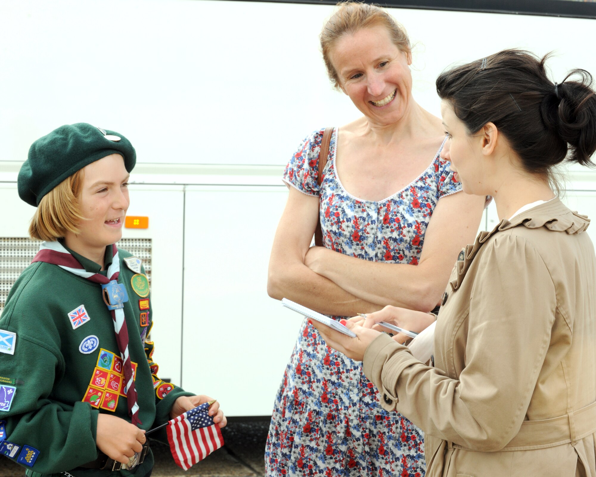 RAF MILDENHALL, England -- Rebecca Gough, Eastern Daily Press reporter, interviews Freedom Scott Tansley while mother Peg Tansley watches following first lady Michelle Obama’s visit to U.S. military families at RAF Mildenhall here July 29, 2012. Families assigned to RAF Mildenhall, RAF Lakenheath and the 501st Combat Support Wing were among the families the first lady met with prior to her departure.  Obama stopped at the base as part of the Joining Forces initiative. While in the U.K., the first lady met with approximately 1,000 British and American children as part of her Let’s Move! campaign and was also the U.S. presidential delegation for the opening ceremony of the 2012 Olympic Games. (U.S. Air Force photo/Master Sgt. Brian M. Boisvert)