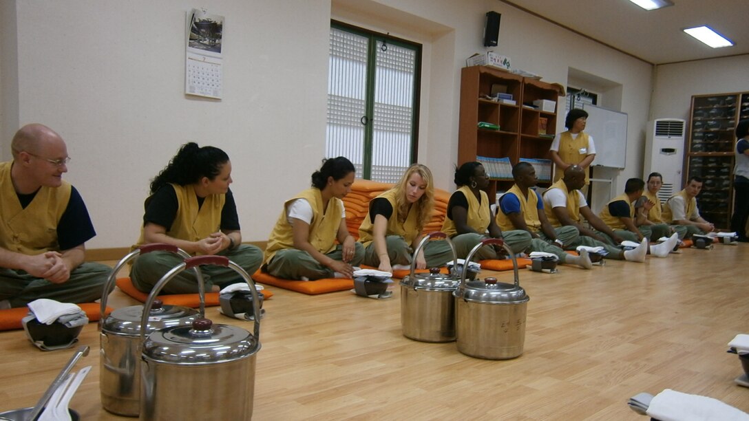 Members of U.S. Forces Korea await their meal during a visit to a Buddhist temple as part of a Korean Cultural Tour July 27-28. The Republic of Korea Ministry of National Defense sponsored the tour designed to introduce USFK service members and their families to Korean history, customs, and traditions. (U.S. Army Photo)