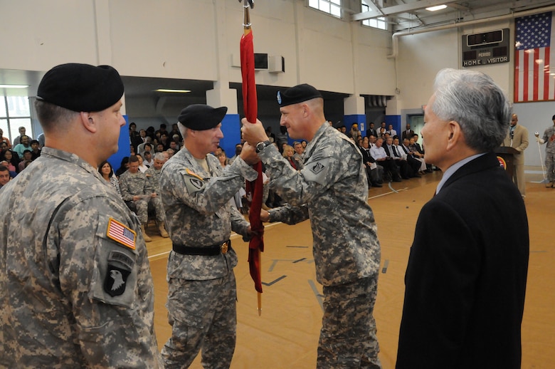Brig. Gen. Richard L. Stevens (center left), Commander, U.S. Army Corps of Engineers, Pacific Ocean Division, passes the Engineer Colors to Col. Donald E. Degidio, Jr. Far East District incoming Commander, during a ceremony on U.S. Army Garrison Yongsan July 8. Col. Blair A. Schantz (left), outgoing Commander, and Jon Iwata, Deputy District Engineer, look on. (Photo by Patrick Bray)