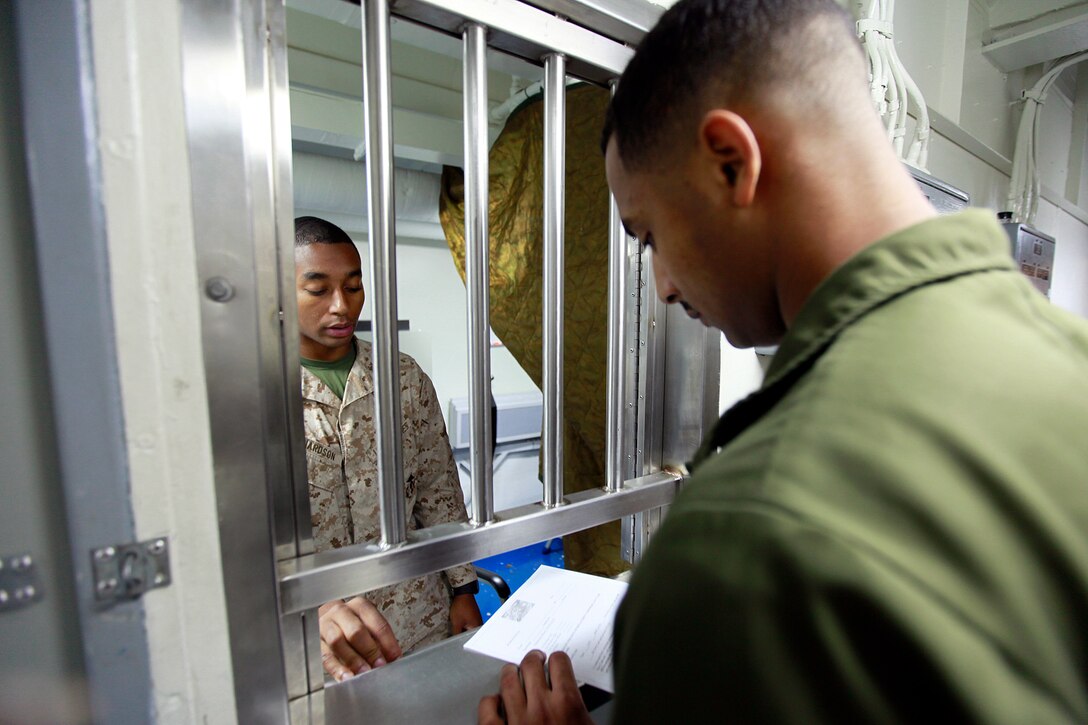 Lance Cpl. Freddie Richardson, disbursing clerk, 15th Marine Expeditionary Unit, assists Sgt. Mohamed R. Muhidin, night crew supervisor, Marine Medium Helicopter Squadron 364, 15th MEU, set up his Marine Cash card, July 29. The Disbursing Office assists Marines and sailors of the MEU by replacing cash with Marine Cash cards to make purchases while embarked on ships in the Peleliu Amphibious Ready Group. However, they do much more than that. Their mission is to provide deployed disbursing support to the troops to ensure they are properly paid and resolve any pay and entitlement problems they may incur.