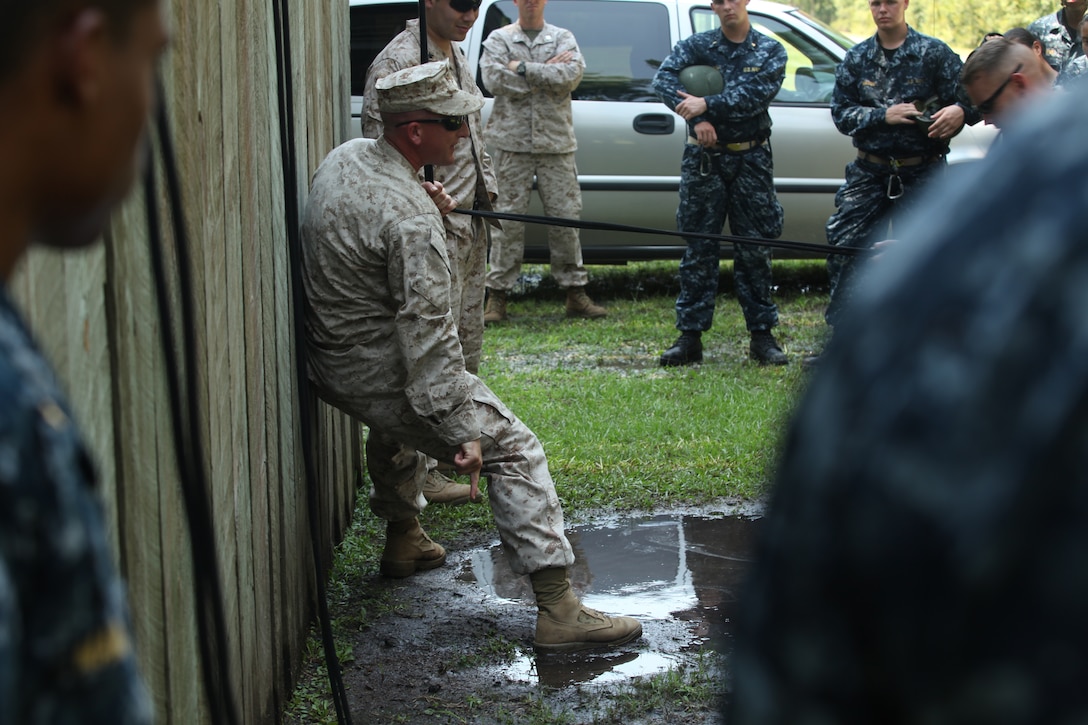 A Marine instructs a platoon of midshipmen how to properly repel down a wall and land safely at a tower aboard Marine Corps Base Camp Lejeune July 24. The midshipmen were aboard MCB Camp Lejeune from July 22 to 27 during Marine Week as part of their Career Orientation and Training for Midshipmen.