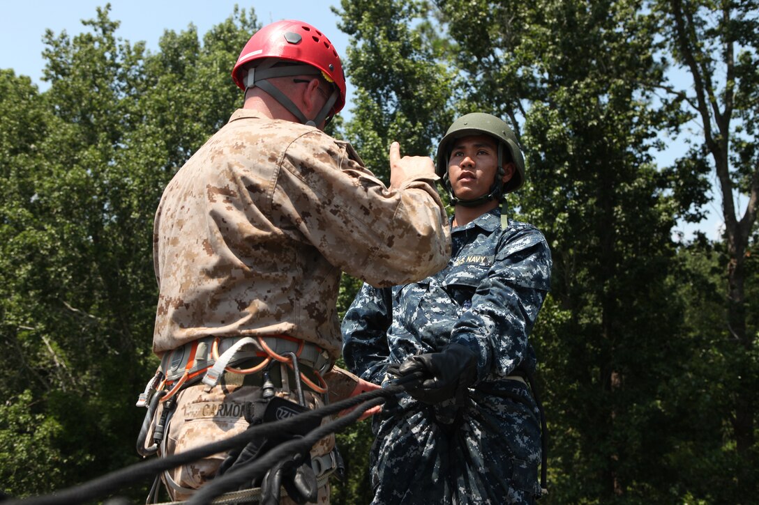 A midshipman prepares to repel down a wall, while listening to the instruction a Marine is giving him aboard Marine Corps Base Camp Lejeune July 24. Many of the midshipmen had never repelled before, so they were eager to learn how.