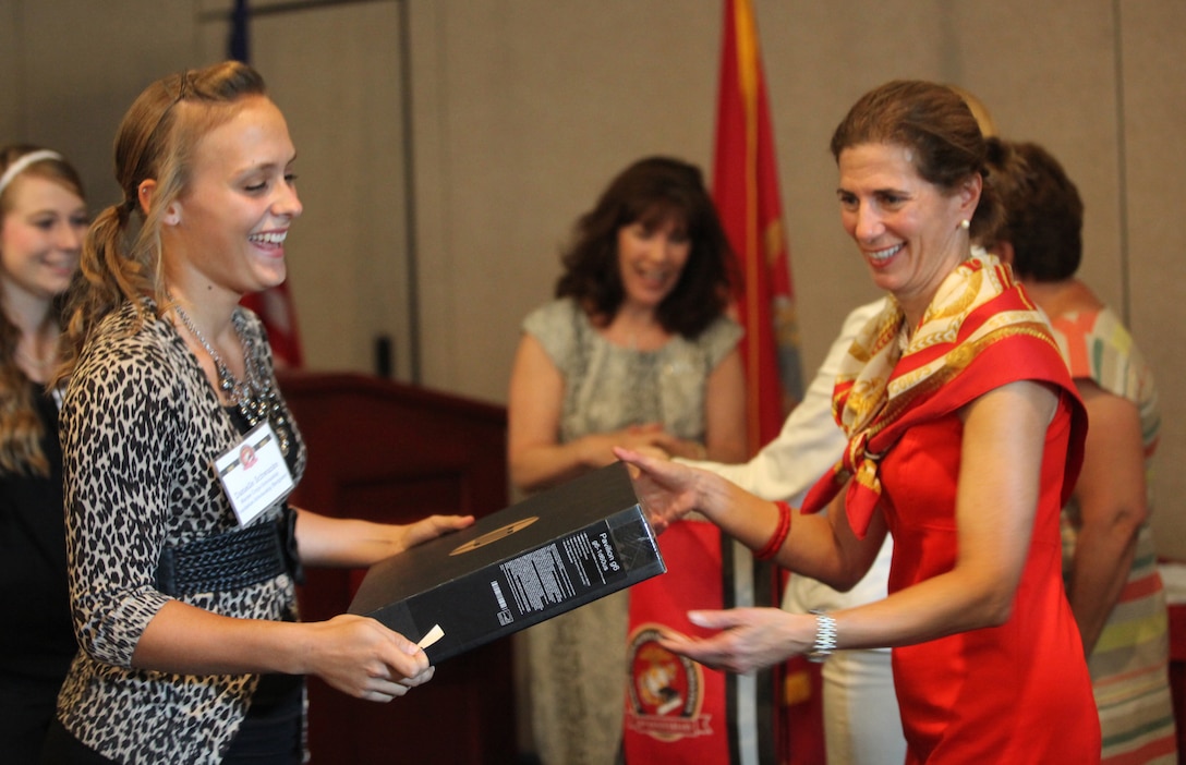 A military child (left) receives a laptop at a certificate ceremony for students who won scholarships from Marine Corps Scholarship Foundation aboard Marine Corps Base Camp Lejeune July 26. The child was one of 26 who received a laptop from Hewlett Packard. 