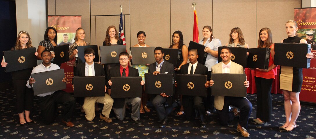 A group of students hold the laptops they won after a random drawing during a Marine Corps Scholarship Foundation ceremony aboard Marine Corps Base Camp Lejeune July 26. The students are 16 of 1,909 who received scholarships from the MCSF this year.