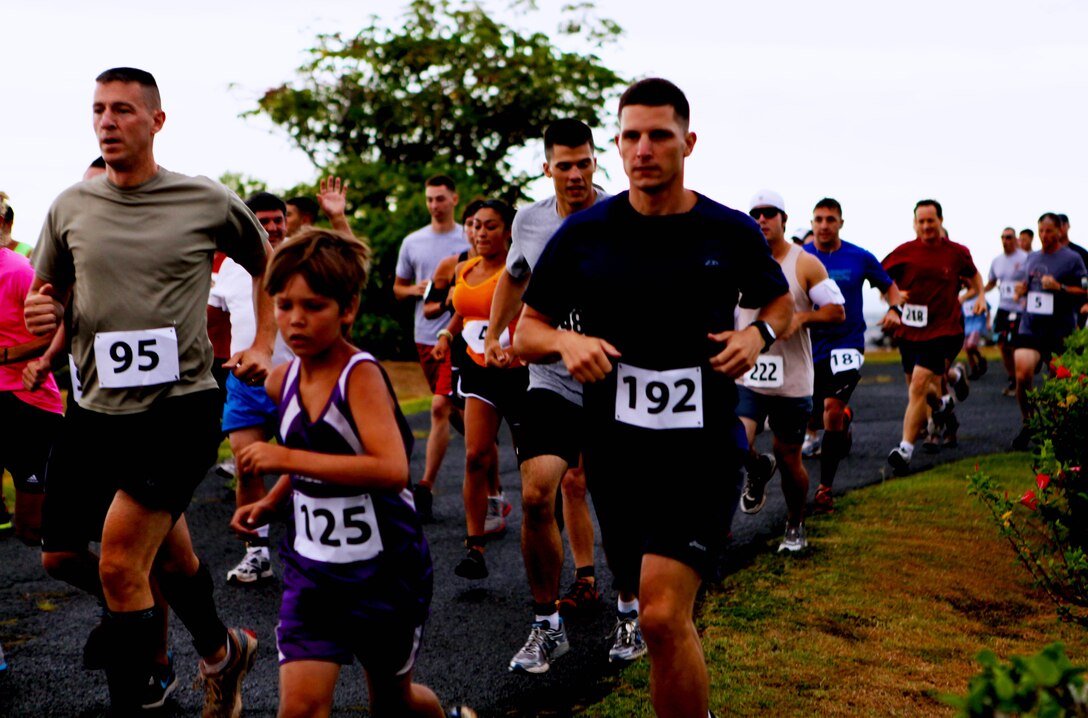 Runners round the first turn, and enjoy one of the only flat portions of the course, during the annual Camp Smith 5K Grueler here, July 28. “They’re wonderful races, but they’re painful,” said Jim Murray, a 60-year-old Honolulu resident who has competed in nearly 20 similar races on Camp H.M. Smith. “The only flat part of this race is (the starting point). After that, you’re either going up or down.” The multiple hills, along with uneven terrain and roots scattered throughout the 3.1-mile course, prompted event organizers to make safety a top priority.