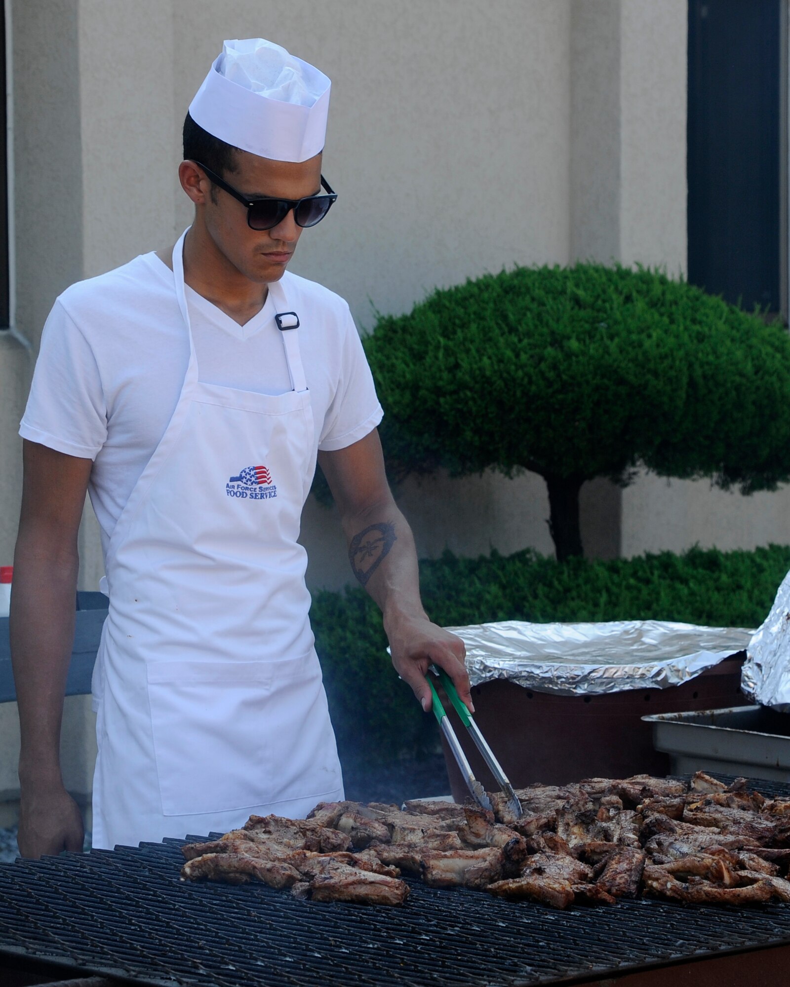 An Airmen helps grill chicken for the first Customer Appreciation Dinner outside the O’Malley Dining Facility at Kunsan Air Base, Republic of Korea, July 27, 2012. Volunteers from around the Wolf Pack helped prepare and serve food during the event. (U.S. Air Force photo/Senior Airman Marcus Morris