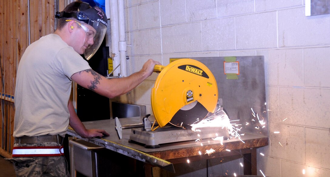 Senior Airman Richard McComb, 28th Maintenance Squadron aircraft structural maintenance journeyman, trims a titanium over wing fairing hydroline in the air structural maintenance building at Ellsworth Air Force Base, S.D., July 26, 2012. The over wing fairing hydroline assists the number two system pressure hydroline on the B-1 bomber, which is essential to safe and correct operation. (U.S. Air Force photo by Airman 1st Class Anania Tekurio/Released)