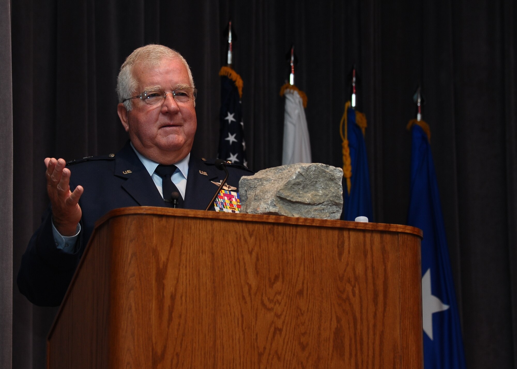 Retired Maj. Gen. Burton Moore gives a speech with his piece of the Berlin Wall to Specialized Undergraduate Pilot Training graduating Class 12-12 July 27 in Kaye Auditorium.  Moore carries the rock with him to all of his speeches as somewhat of a good luck charm.  (U.S. Air Force Photo/Senior Airman Chase Hedrick)