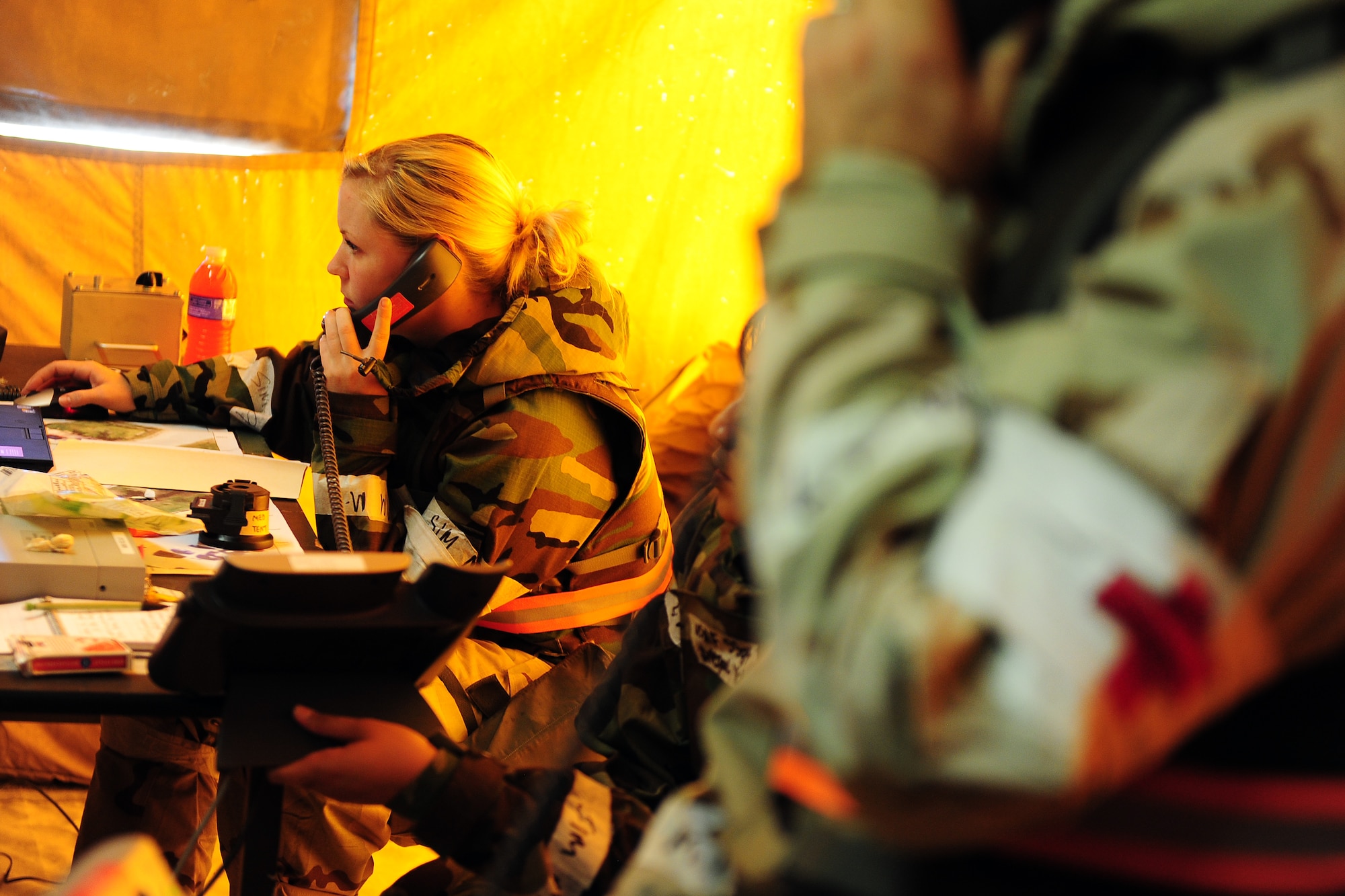 U.S. Air Force Airman 1st Class Christina Claycamp, 55th Medical Operations Squadron, check the status of patients in and around the medical tents of “Base X” as part of an Operational Readiness Exercise at Offutt Air Force Base, Neb., July 27.  Airman at Offutt go through rigorous training to insure they a ready to perform their duties proficiently while in deployed locations around the world. (U.S. Air Force Photo by Josh Plueger/Released)