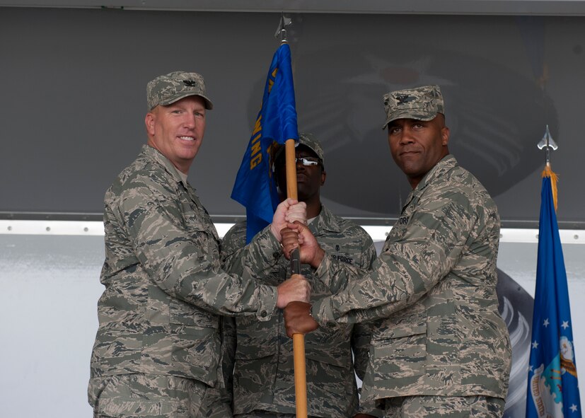 U.S. Air Force Col. Steven Ramer, 23d Wing vice commander, passes the guidon to Col. Alvis Headen, new 23d Medical Group commander, during a change of command ceremony July 27, 2012, at Moody Air Force Base, Ga. The CoC ceremony is a military tradition that represents a formal transfer of authority from one leading commander to the other. (U.S. Air Force photo by Senior Airman Eileen Meier/Released)