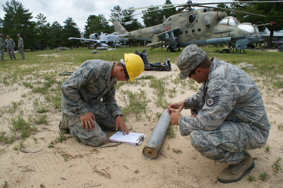Airman Ryan Vaughn (left) reviews his checklist during a SUU-25 download exercise as EOD instructor Staff Sgt. Charles Howell looks on Jul. 20, 2012 at Eglin Air Force Base, Florida.  The download exercise is part of the training in the Air Division of NAVSCOLEOD.  (U.S. Air Force photo/Dan Hawkins)