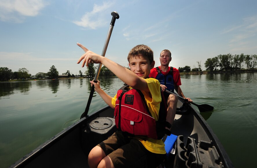 Nine year-old Chris Stewart and Offutt volunteer U.S. Air Force Tech. Sgt. Chris Wroegler navigate their canoe around the Offutt Base Lake during the Exceptional Family Members Program’s Camp Offutt July 12 at Offutt AFB, Neb.    This is the second year Offutt’s Exceptional Family Member Program has put on the camp to inspire the youth and enhance their confidence.  (U.S. Air Force photo by Josh Plueger/Released)