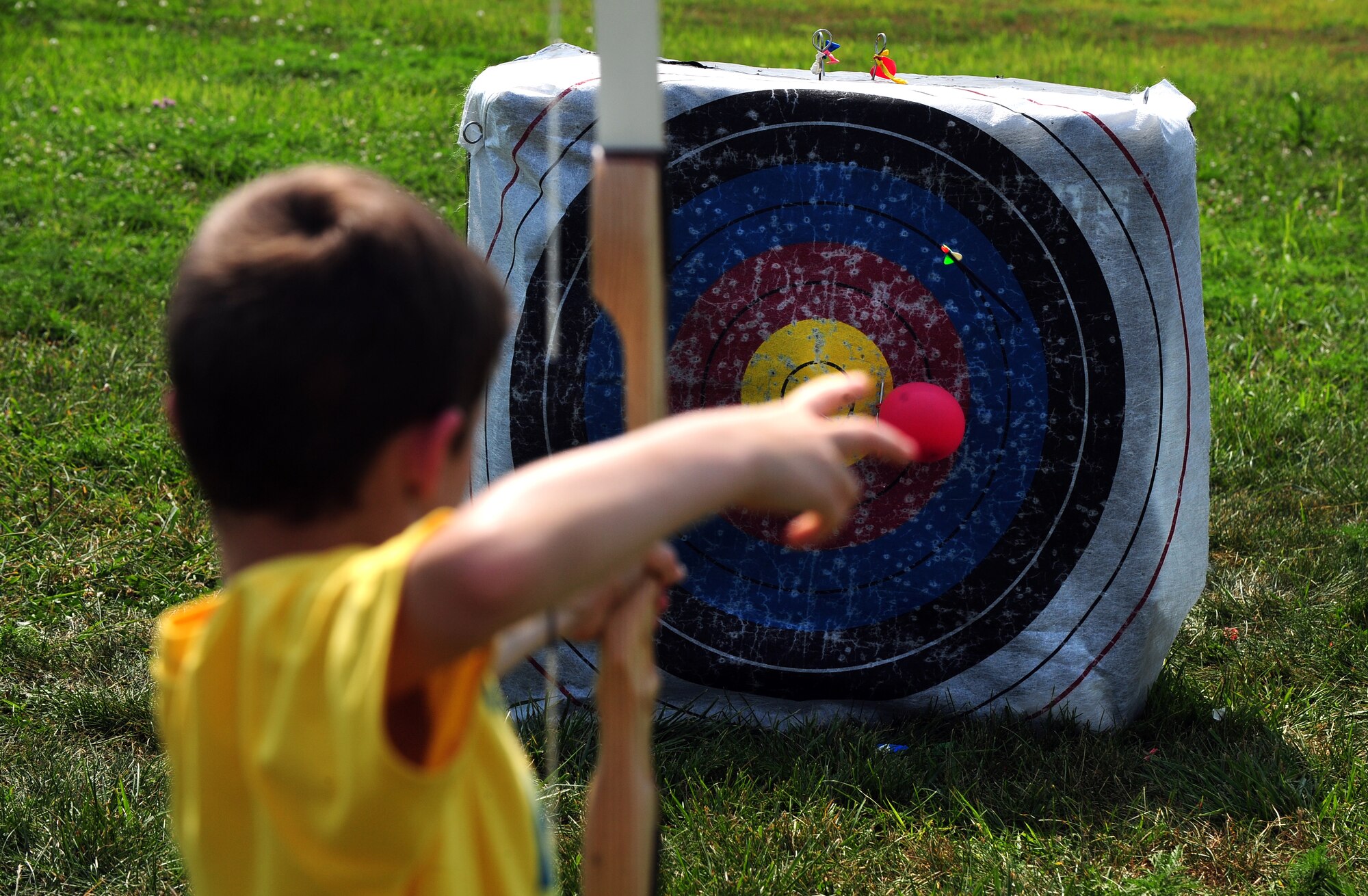 Eight year-old Michael “Mikey” Holt takes aim at the bulls-eye while honing his archery skills during the Exceptional Family Members Program’s Camp Offutt July 12 at Offutt AFB, Neb.  The children spend two days at camp doing several activities from archery to boating.  (U.S. Air Force photo by Josh Plueger/Released)