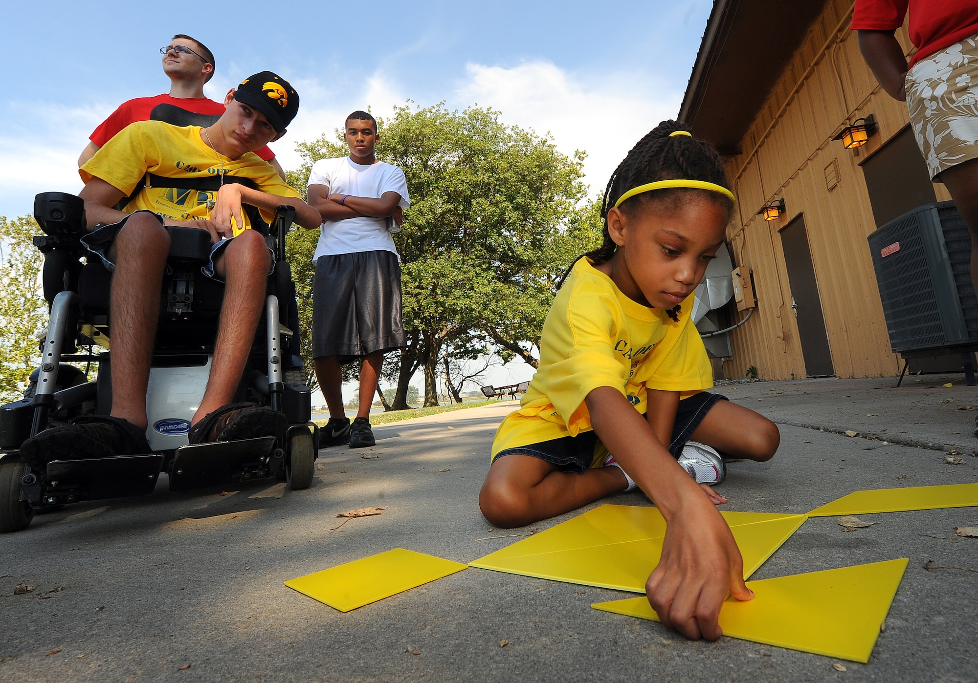 Six year-old Jordan Baker works with geometric shapes to make an abstract fish while participating in team building exercises at the Offutt Base Lake while attending the Exceptional Family Members Program’s Camp Offutt July 12 at Offutt AFB, Neb.  This is the second year Offutt’s Exceptional Family Member Program has hosted Camp Offutt.  (U.S. Air Force photo by Josh Plueger/Released)