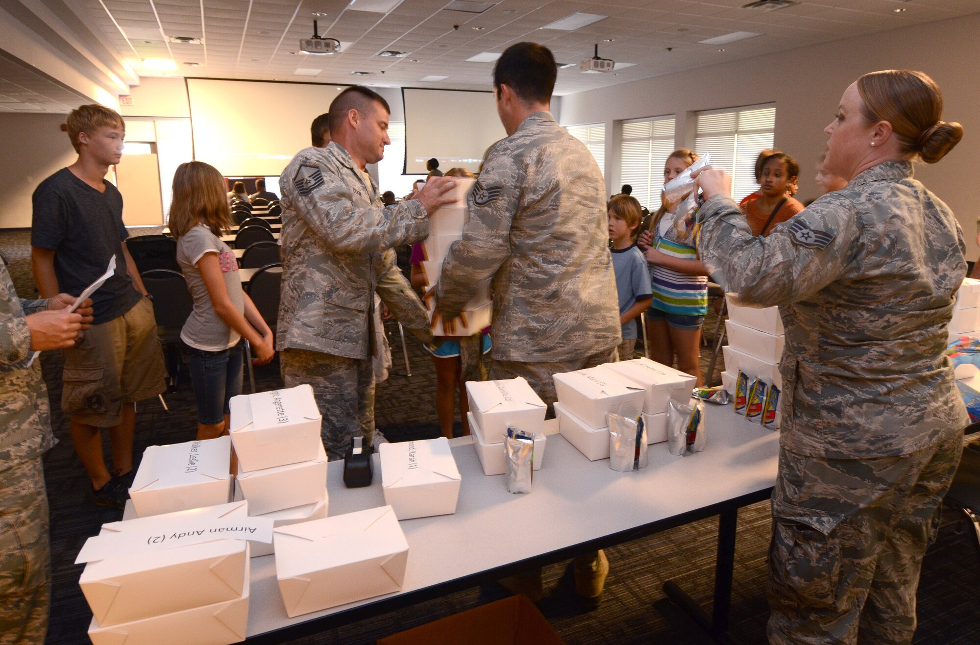 Parents and kids pick up their lunches prior to the start of the movie during the annual Bring Your Kids to Work Day at Dobbins Air Reserve Base, July 27. Members of Dobbins ARB were able to bring their kids to their places of work, then to a hangar with several hands-on displays of equipment utilized on the base and also to the C-130 flight simulator. (U.S. Air Force photo/Brad Fallin)