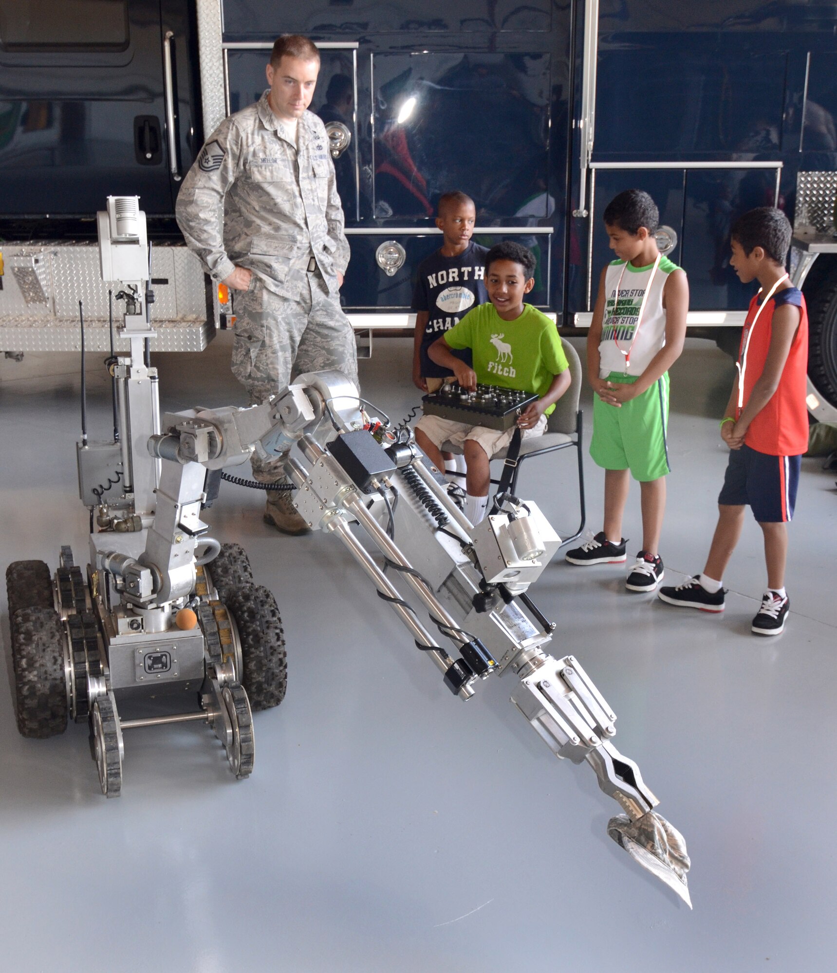 Master Sgt. Jason Mellor, an EOD specialist helps kids operate the bomb disposal robot during the annual Bring Your Kids to Work Day at Dobbins Air Reserve Base, July 27. Members of Dobbins ARB were able to bring their kids to their places of work, then to a hangar with several hands-on displays of equipment utilized on the base and also to the C-130 flight simulator.  (U.S. Air Force photo/Brad Fallin)